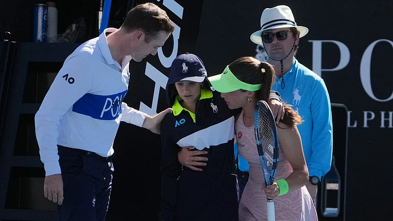 Zeynep Sonmez of Turkey and umpire Chase Urban help a ball kid who fainted, from the court during her first round match against Ekaterina Alexandrova of Russia at the Australian Open tennis championship in Melbourne, Australia, Sunday, Jan. 18, 2026. - | Photo: AP/Asanka Brendon Ratnayake
