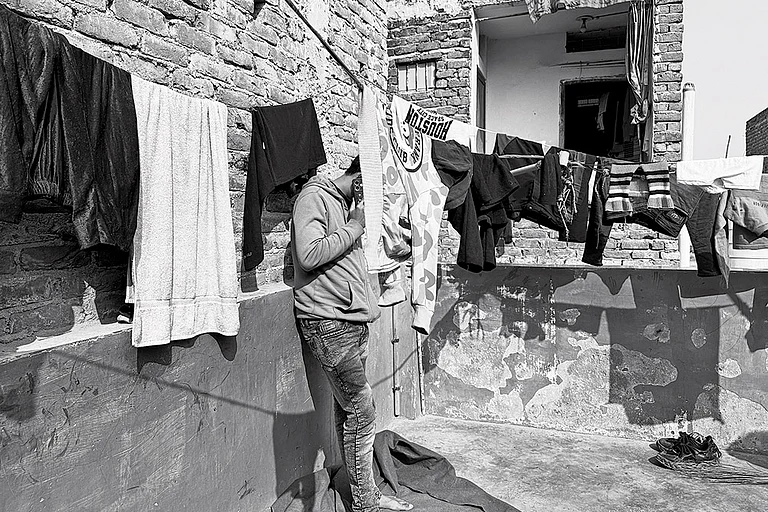 Life, Altered: Mohammad Iqbal stands in the balcony of his mother-in-law’s house in one of the localities of North-east Delhi - | Photo: Mrinalini Dhyani