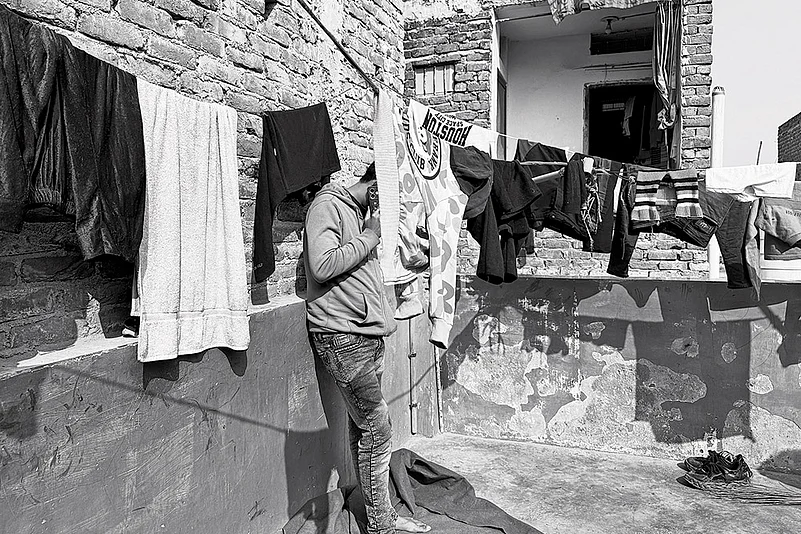 Mohammad Iqbal stands in the balcony of his mother-in-law’s house in one of the localities of Delhi