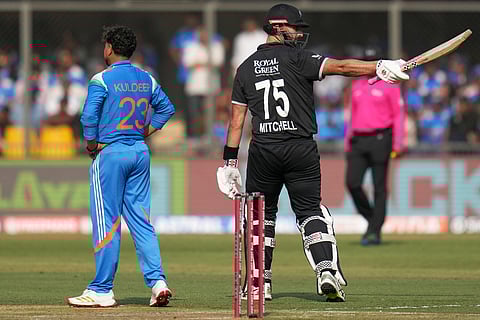 New Zealand's Daryl Mitchell, right, celebrates his fifty runs as India's Kuldeep Yadav looks on during the third One Day International cricket match between India and New Zealand in Indore, India.