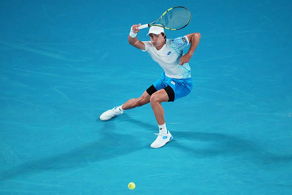 Adam Walton of Australia plays a forehand return to Carlos Alcaraz of Spain