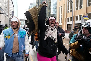 (AP Photo/Yuki Iwamura) : A pro-immigration protester lifts up Jake Lang's vest after an altercation at the March Against Minnesota Fraud rally near Minneapolis City Hall, Saturday, Jan. 17, 2026, in Minneapolis.