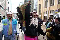 (AP Photo/Yuki Iwamura) : A pro-immigration protester lifts up Jake Lang's vest after an altercation at the March Against Minnesota Fraud rally near Minneapolis City Hall, Saturday, Jan. 17, 2026, in Minneapolis. 
