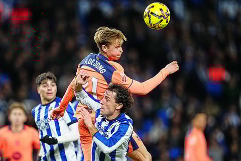 Barcelona's Frenkie de Jong, centre, heads the ball during the Spanish La Liga soccer match between Real Sociedad and Barcelona in San Sebastian, Spain.