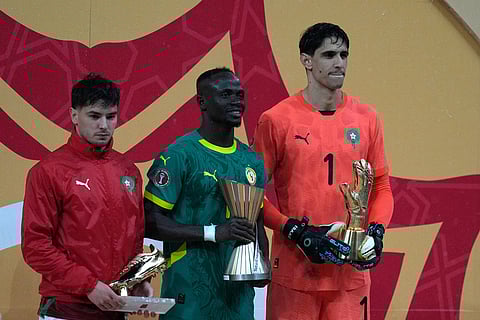Morocco's Brahim Abdelkader Díaz, left, holds the trophy for the best score, Senegal's Sadio Mane, center, holds trophy for the best player and Morocco's goalkeeper Yassine Bounou the trophy for the best goalkeeper of the tournament after the Africa Cup of Nations final soccer match between Senegal and Morocco, in Rabat, Morocco.