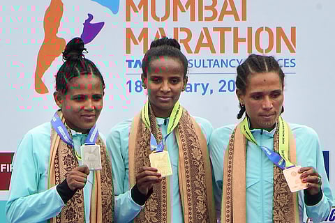 From left, runner-up Kidsan Alema Gebremedhin, winner Yeshi Kalayu Chekole and third-place finisher Gojjam Tsegaye Enyew in the International Elite Women’s category of the Tata Mumbai Marathon 2026, in Mumbai.