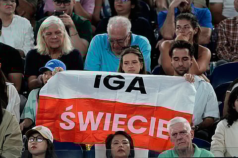 Supporters of Iga Swiatek of Poland hold up a banner during her first round match against Yuan Yue of China at the Australian Open tennis championship in Melbourne, Australia.