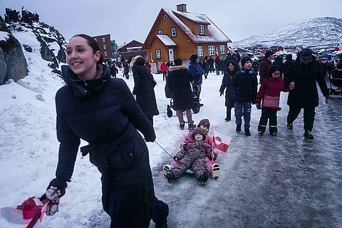 A woman pulls her children on a sled during a protest against Trump's policy towards Greenland in front of the US consulate in Nuuk, Greenland.
