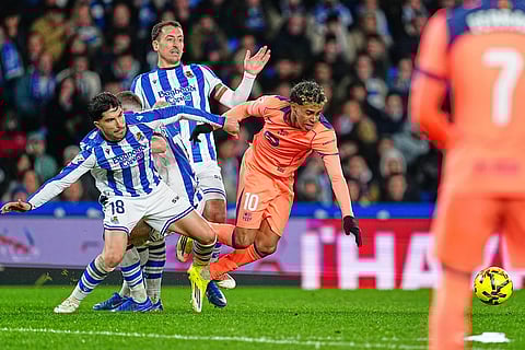 Real Sociedad's Carlos Soler, left, challenges for the ball with Barcelona's Lamine Yamal during the Spanish La Liga soccer match between Real Sociedad and Barcelona in San Sebastian, Spain.
