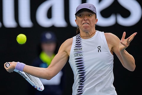 Iga Swiatek of Poland plays a forehand return to Yuan Yue of China during their first round match at the Australian Open tennis championship in Melbourne, Australia.