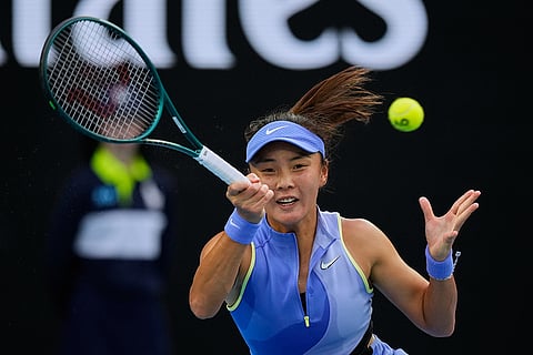 Yuan Yue of China plays a forehand return to Iga Swiatek of Poland during their first round match at the Australian Open tennis championship in Melbourne, Australia.