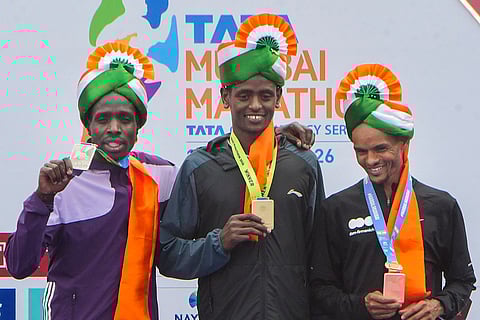 From left, runner-up Leonard Langat, winner Tadu Abate Deme and third-place finisher Merhawi Kesete Weldemaryam in the International Elite Men’s category of the Tata Mumbai Marathon 2026, in Mumbai.
