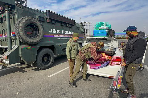 Police personnel check a vehicle on Jammu-Srinagar National Highway ahead of Republic Day, at Qazigund in Kulgam district, Jammu and Kashmir.