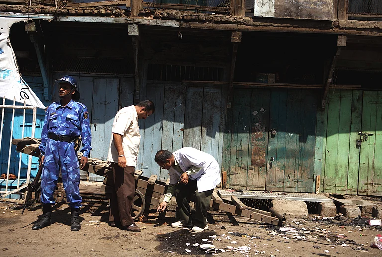Rapid Action Force commando keeps vigil as experts from Forensic Science department examine debris after the 29th September 2008 bomb blast in Malegaon - IMAGO / had fotos