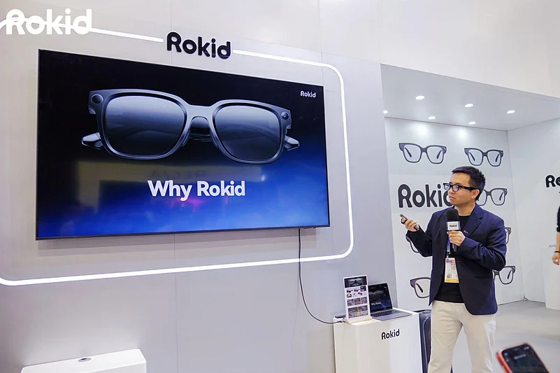 Presenter demonstrating Rokid smart glasses at a technology exhibition booth