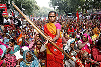 From Forest To Prison, When Security Laws Criminalise Adivasi Resistance | Photo: IMAGO/Hindustan Times : A tribal supporter of Indian anti-corruption activist Anna Hazare posing with a bow and arrow during a protest at Jantar Mantar.