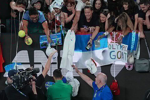 Novak Djokovic of Serbia signs autographs after defeating Pedro Martinez of Spain in their first round match at the Australian Open tennis championship in Melbourne, Australia.
