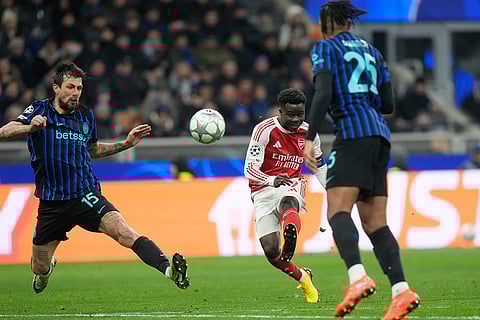 Arsenal's Bukayo Saka, centre, attempts a goal during the Champions League opening phase soccer match between Inter Milan and Arsenal in Milan, Italy.