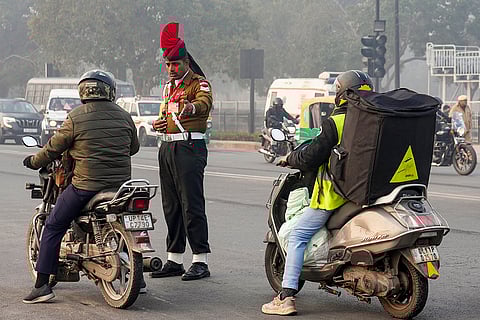 An army police official interacts with a commuter at a traffic signal, during rehearsals for the Republic Day Parade on a cold winter morning, in New Delhi.