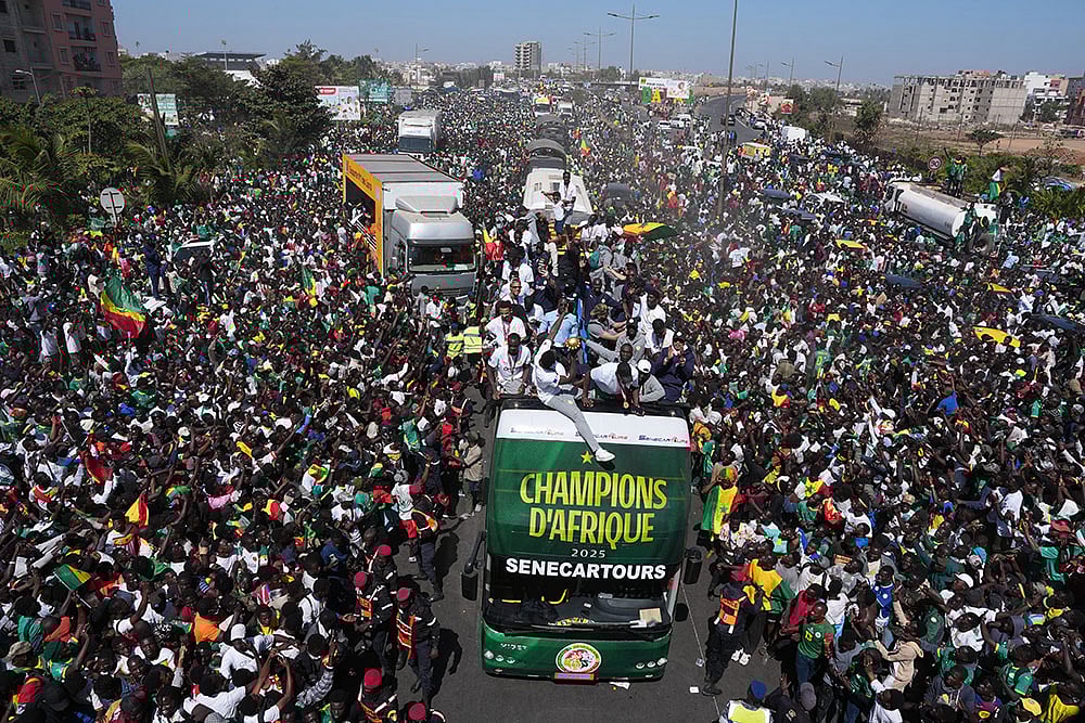 The Senegalese soccer team rides through thousands of cheering fans celebrating their victory in the Africa Cup of Nations soccer tournament, in Dakar, Senegal. - | Photo: AP/Misper Apawu
