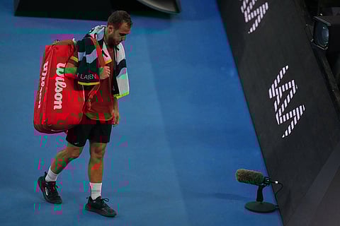 Hugo Gaston of France walks from the court after retiring from his first round match against Jannik Sinner of Italy at the Australian Open tennis championship in Melbourne, Australia.