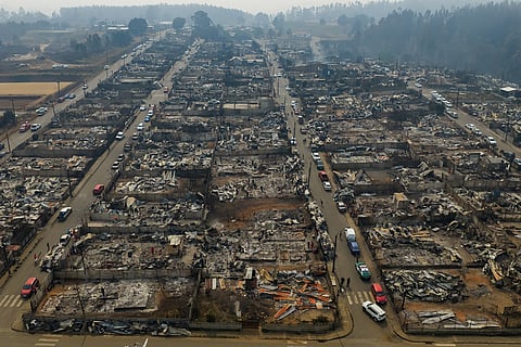 Residential areas burned by wildfires stretch across Tome, Chile.