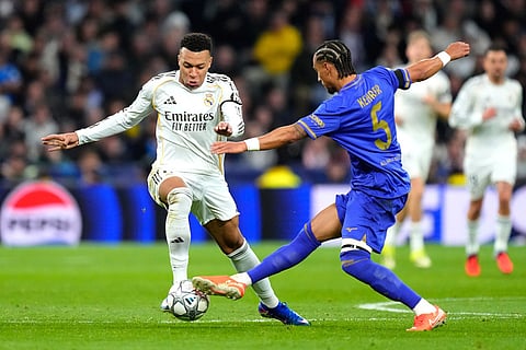 Real Madrid's Kylian Mbappe fights for the ball against Monaco's Thilo Kehrer during the Champions League opening phase soccer match between Real Madrid and Monaco in Madrid.