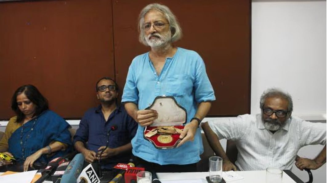 Filmmaker Anand Patwardhan displays his returned National Award at a Mumbai press conference.