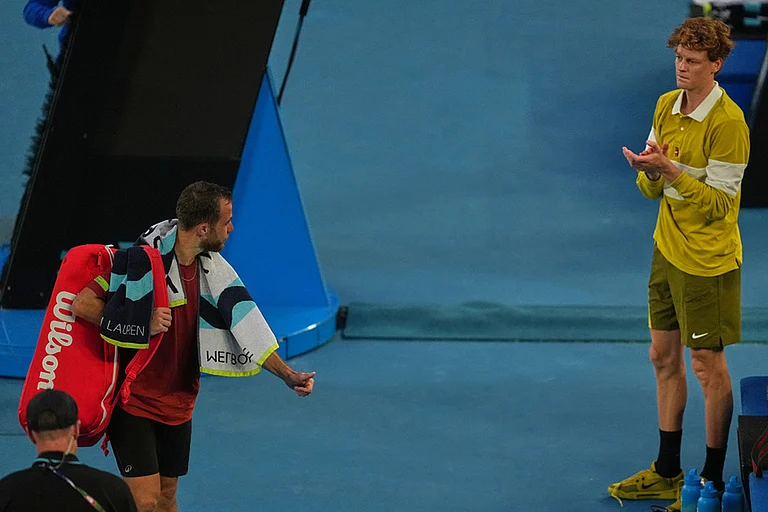 Hugo Gaston, left, of France walks from the court after retiring from his first round match against Jannik Sinner, right, of Italy at the Australian Open tennis championship in Melbourne, Australia. - | Photo: AP/Asanka Brendon Ratnayake