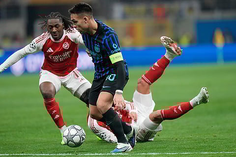 Inter Milan's Lautaro Martinez, centre, tries to dribble past Arsenal's Eberechi Eze during the Champions League opening phase soccer match between Inter Milan and Arsenal in Milan, Italy.