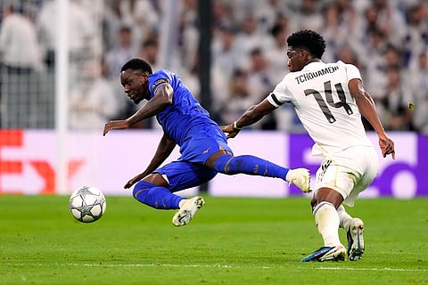 Real Madrid's Aurelien Tchouameni fights for the ball against Monaco's Folarin Balogun during the Champions League opening phase soccer match between Real Madrid and Monaco in Madrid.