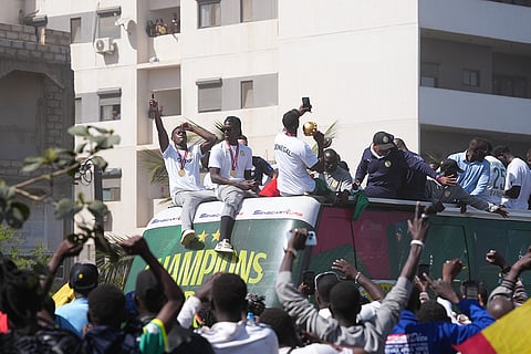 The Senegalese soccer team rides through thousands of cheering fans celebrating their victory in the Africa Cup of Nations soccer tournament, in Dakar, Senegal.
