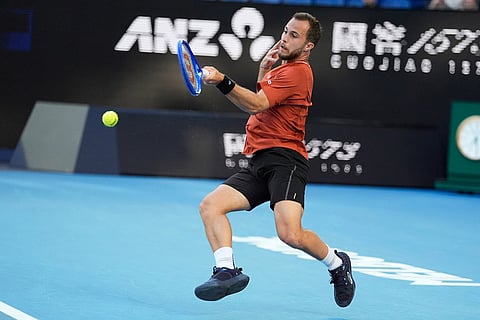 Hugo Gaston of France plays a forehand return to Jannik Sinner of Italy during their first round match at the Australian Open tennis championship in Melbourne, Australia.
