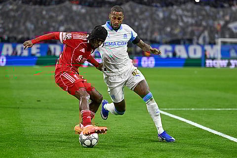 Liverpool's Jeremie Frimpong, left, challenges for the ball with Marseille's Michael Murillo during the Champions League opening phase soccer match between Marseille and Liverpool in Marseille, France.