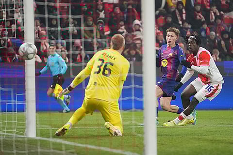 Barcelona's Fermin Lopez, center, scores his side's opening goal past Slavia's David Moses, right, and Slavia's goalkeeper Jindrich Stanek during the Champions League opening phase soccer match between Slavia Prague and Barcelona in Prague, Czech Republic.