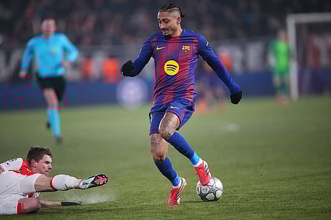Barcelona's Raphinha, right, is challenged by Slavia's David Doudera during the Champions League opening phase soccer match between Slavia Prague and Barcelona in Prague, Czech Republic.