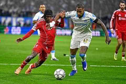 Liverpool's Jeremie Frimpong, left, challenges for the ball with Marseille's Michael Murillo during the Champions League opening phase soccer match between Marseille and Liverpool in Marseille, France.