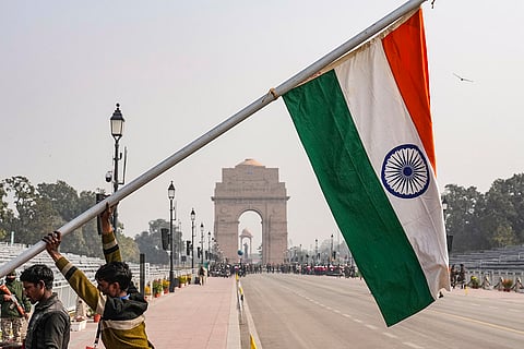 Workers raise a pole bearing the Indian national flag during rehearsals for the Republic Day Parade, near the India Gate, in New Delhi.