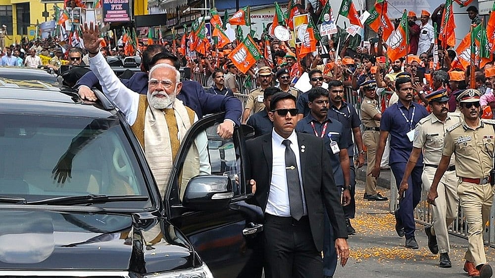 In this image released on Jan. 23, 2026, Prime Minister Narendra Modi greets people during a roadshow upon his arrival, in Thiruvananthapuram. - | Photo: PMO via PTI