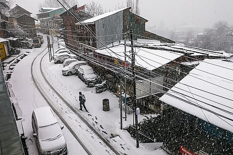 A citizen walks amid heavy snowfall at Bhaderwah, in Doda district, Jammu and Kashmir.