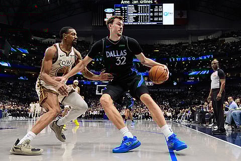 Dallas Mavericks forward Cooper Flagg (32) works against Golden State Warriors guard De'anthony Melton, left, in the second half of an NBA basketball game in Dallas.