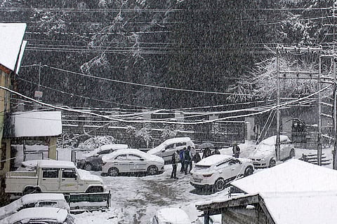 People brave heavy snowfall at Manali, in Kullu district, Himachal Pradesh.