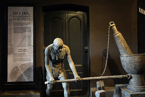 The display features a sculpture of a prisoner operating a dhenki (a traditional husking lever) to grind materials, a form of hard labor imposed on inmates.