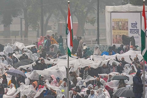 Attendees take cover under plastic sheets during rain-affected full-dress rehearsal for the Republic Day Parade, in New Delhi.