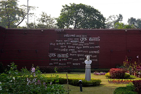The text on the wall is the first stanza of the famous Bengali poem "Karar Oi Louho Kopat" by revolutionary poet Kazi Nazrul Islam. In the back drop of Nehru statue in Alipore jail museum.