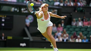 | Photo: AP/Alberto Pezzali : Croatia's Jana Fett stretches to return to Poland's Iga Swiatek in a first round women's singles match on day two of the Wimbledon tennis championships in London, Tuesday, June 28, 2022.
