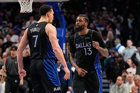 Dallas Mavericks' Dwight Powell (7) and Naji Marshall (13) celebrate in the second half of an NBA basketball game against the Golden State Warriors in Dallas.