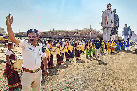 A police officer manages the crowd at the venue where three people were allegedly injured after a banner collapsed ahead of the start of a programme in Hubballi, Karnataka.