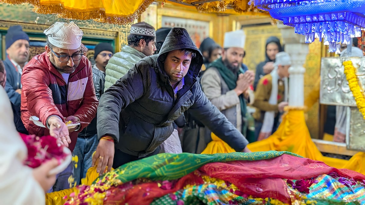 A Devotee offering a chadar on the saints tomb.
