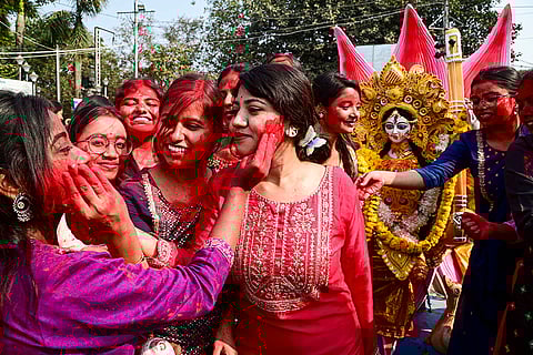 Nursing college students take part in the immersion procession of a Goddess Saraswati idol on the banks of the Hooghly river in Kolkata.